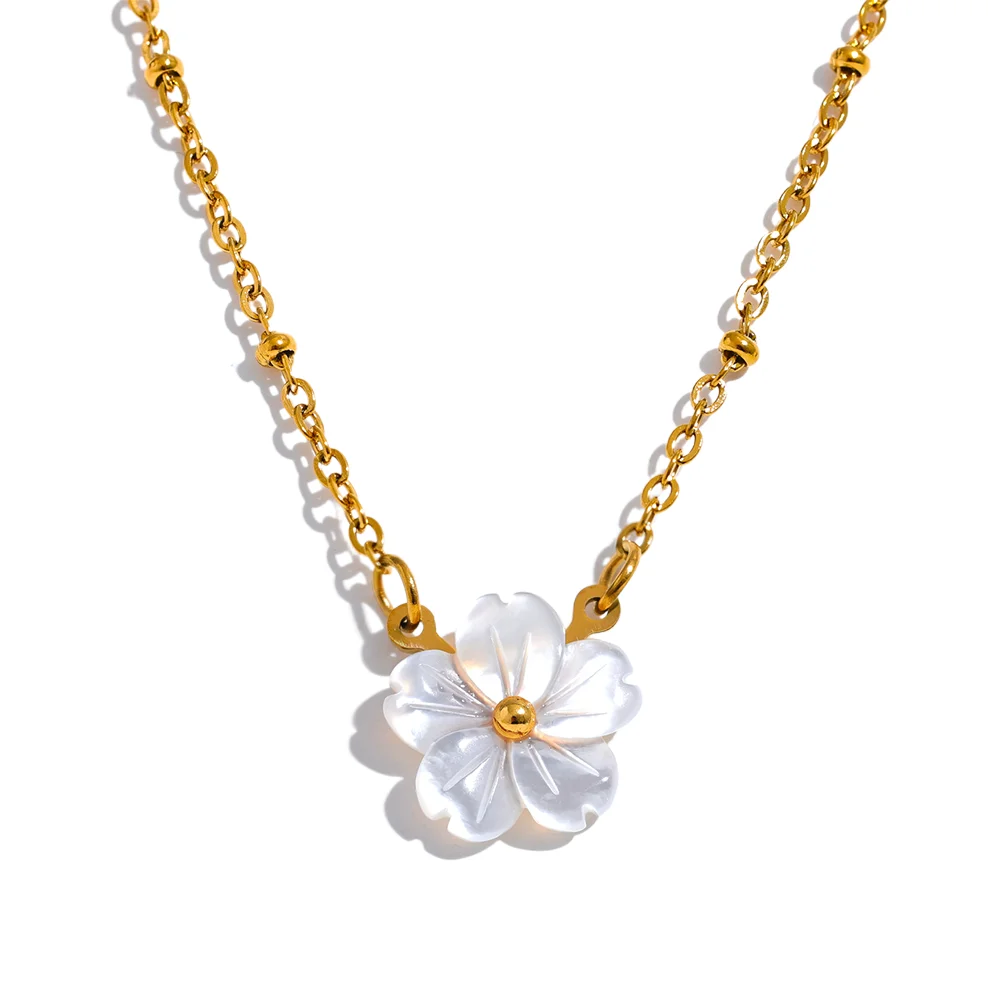 Gold necklace with a white floral pendant on a white background
