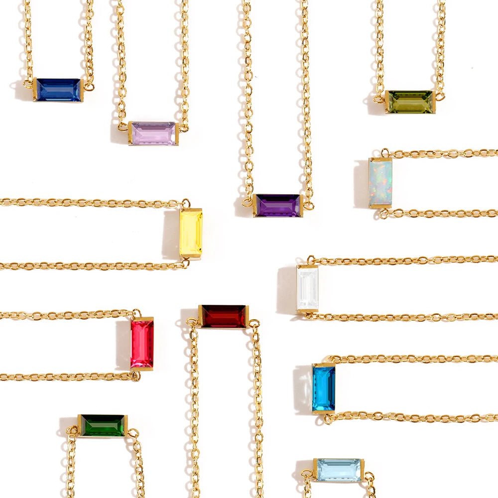 Gold necklaces with rectangular gemstones on a white background