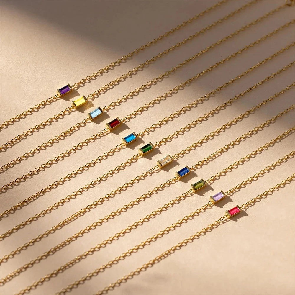 Gold chains with colorful beads on a beige background