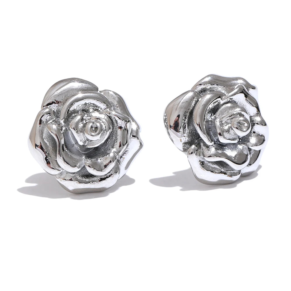 Silver rose-shaped earrings on a white background