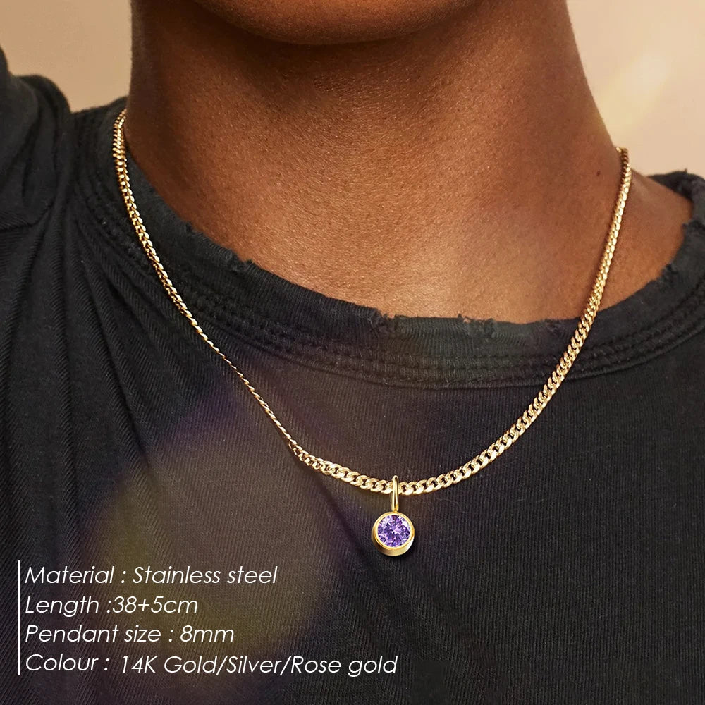 Gold necklace with a purple pendant on a person wearing a black top.