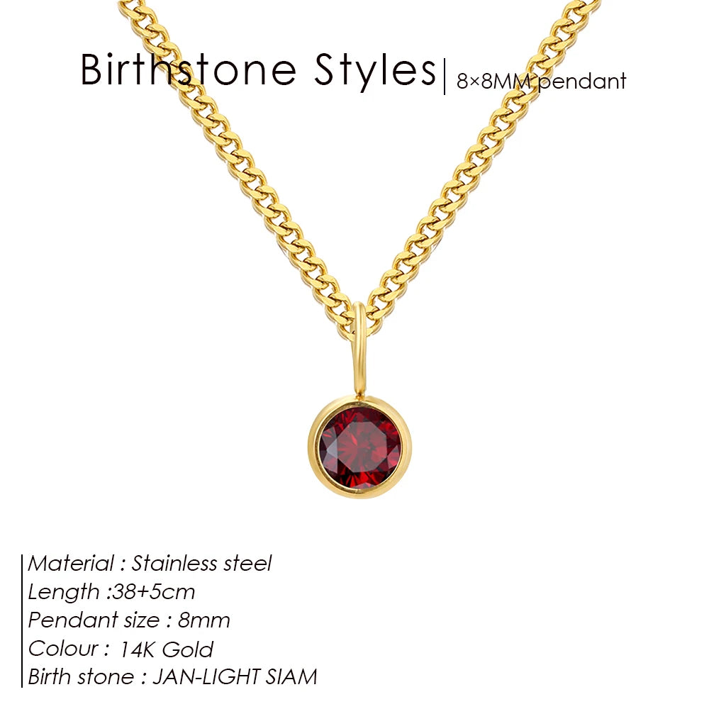 Gold necklace with a red gemstone pendant on a white background