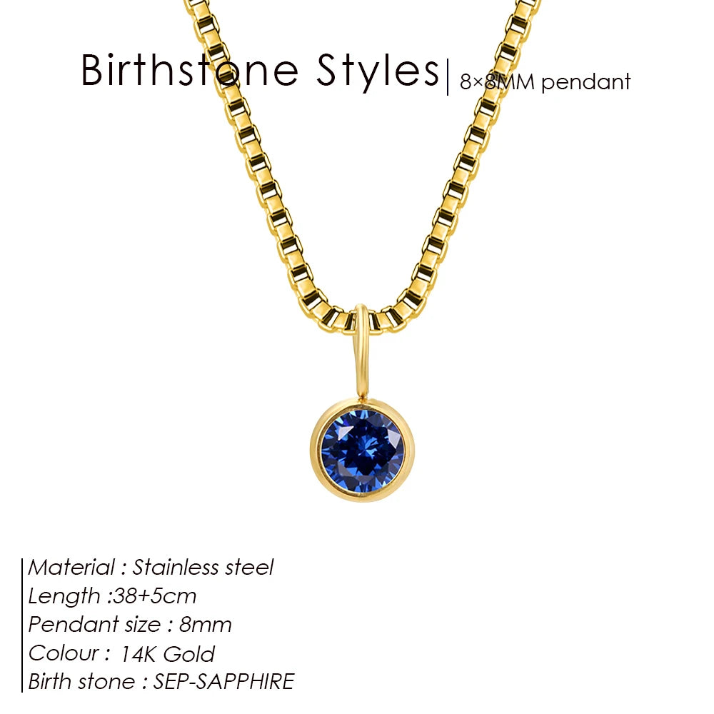Gold necklace with a blue sapphire pendant on a white background
